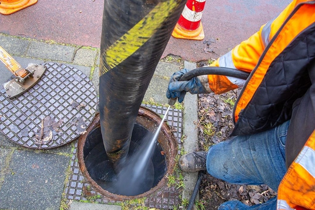 Technician using high-pressure hydro jetting equipment to clean a sewer line in Franktown.