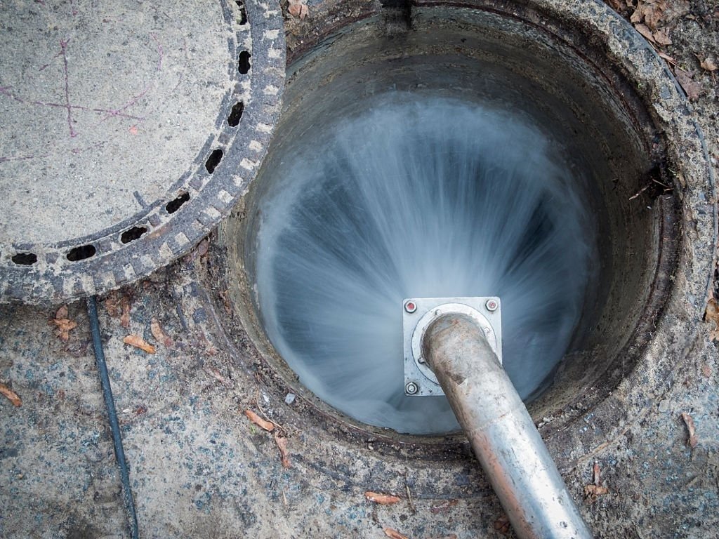 High-pressure sewer hydro jetting equipment cleaning an underground drain line in Buffalo Creek.