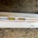 New white PVC sewer pipe installed in a trench, labeled Schedule 40 PVC