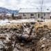 Cracked sewer line exposed by frost heave in a snowy Colorado yard